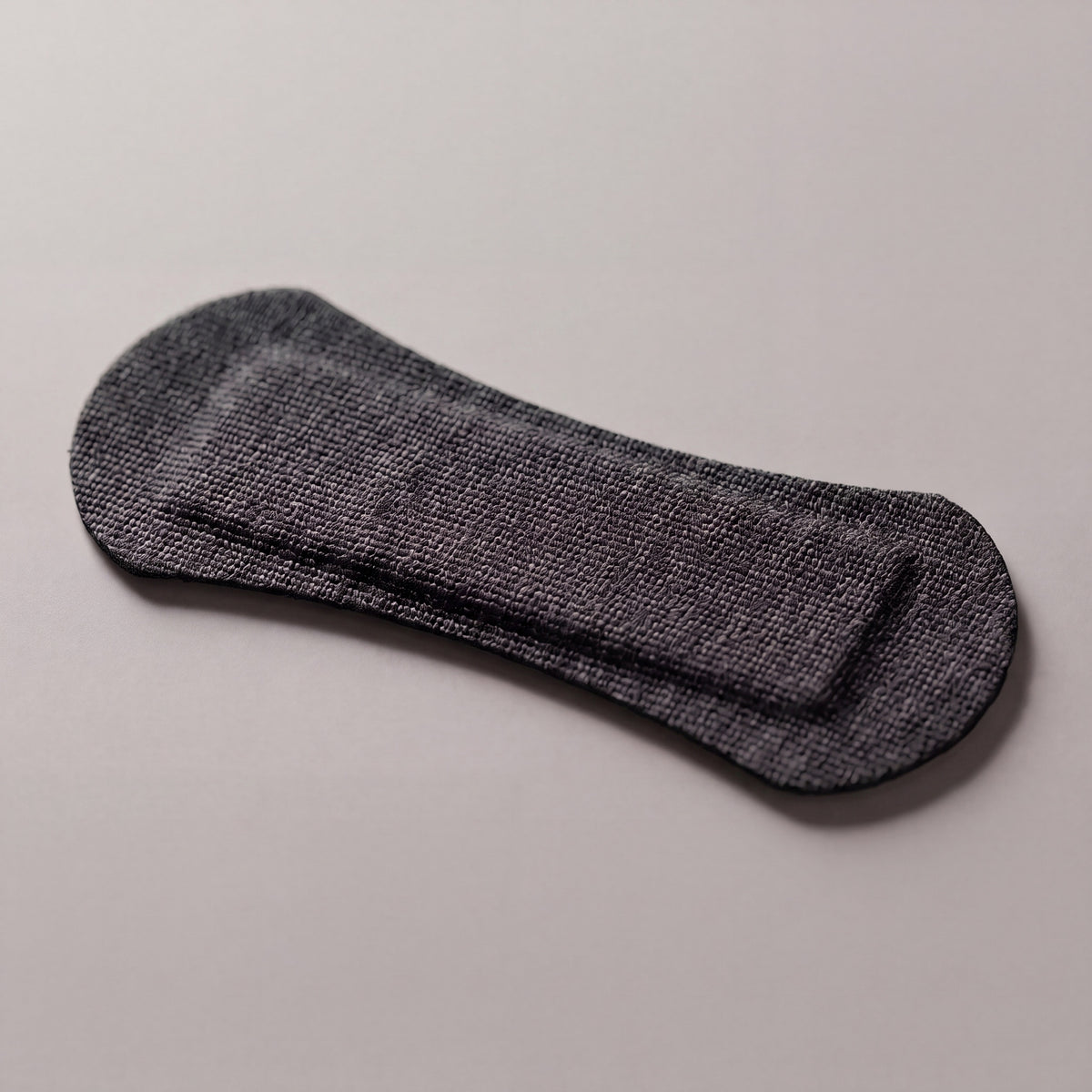 Black RYVENA nose strip angled to show the raised spring band that lifts the nasal passage