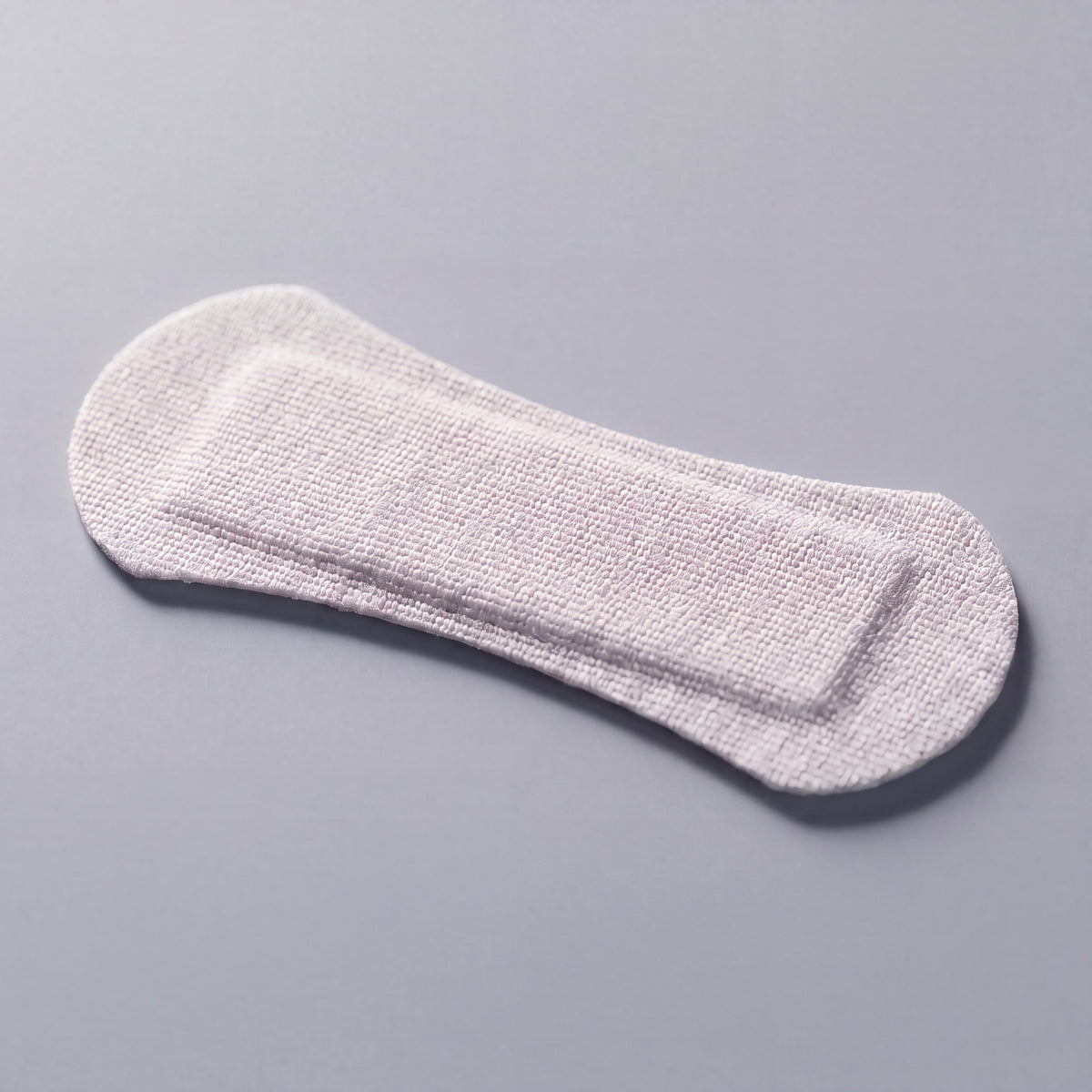 White RYVENA nose strip angled to show the raised spring band that lifts the nasal passage