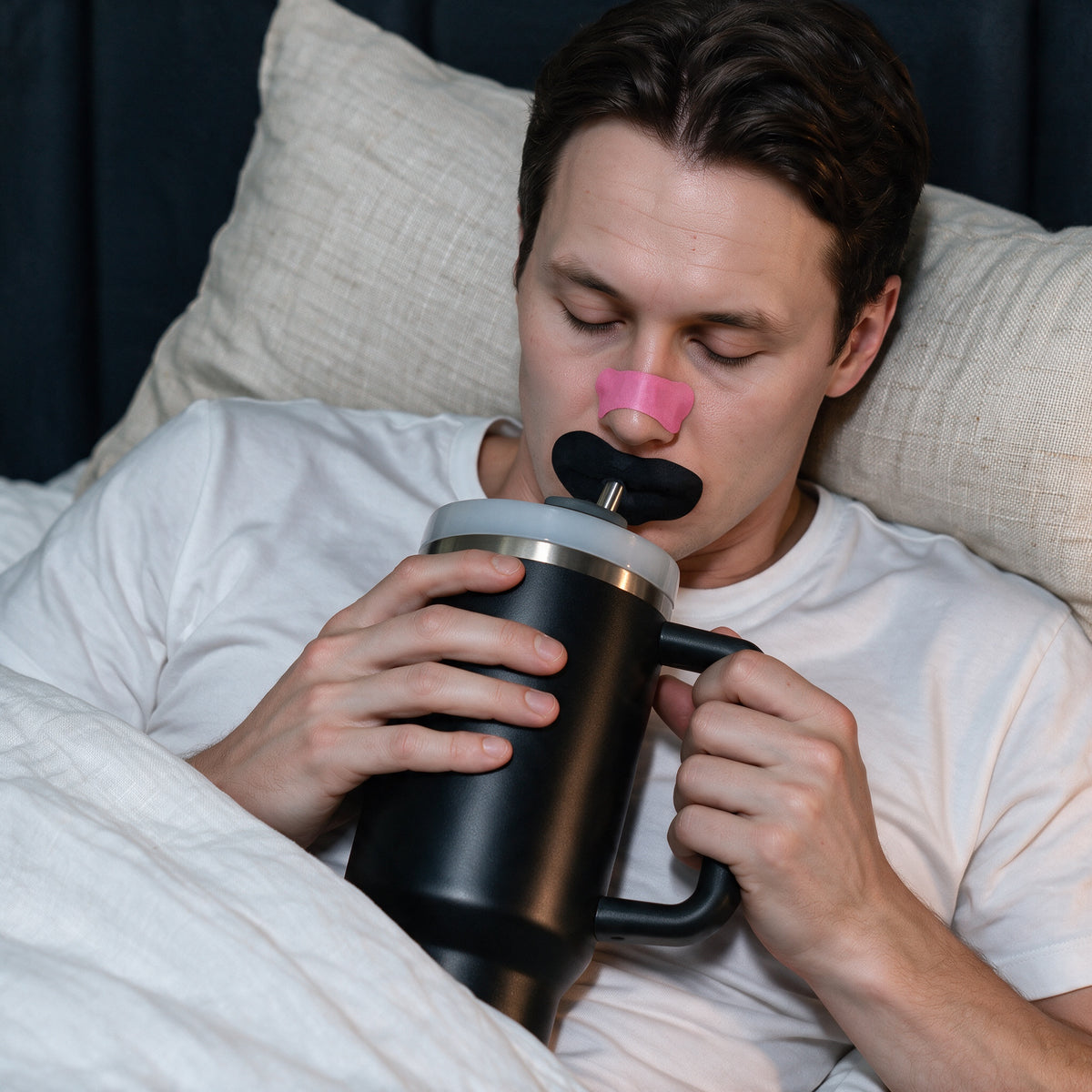 Man drinking through the central vent slot without removing his mouth tape