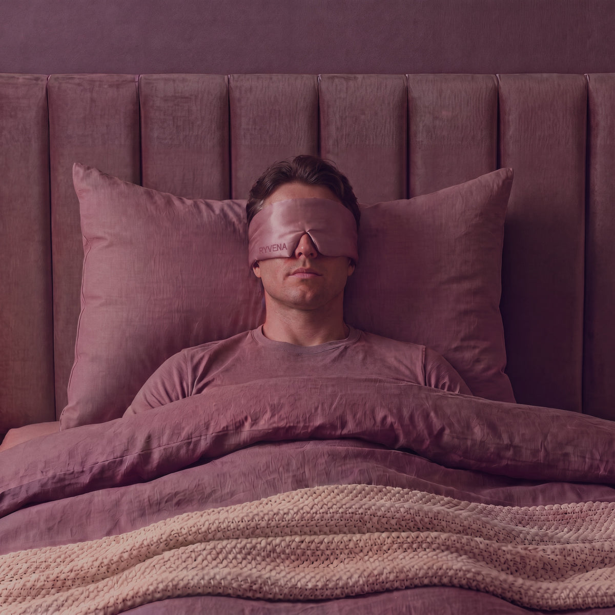 Man sleeping wearing a RYVENA blush pink silk sleep mask