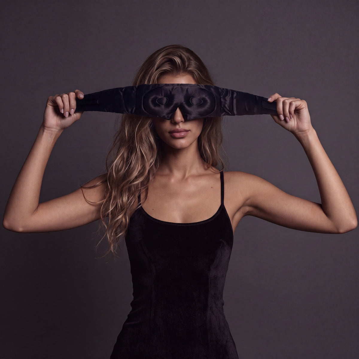 Woman holding a RYVENA deep black silk sleep mask