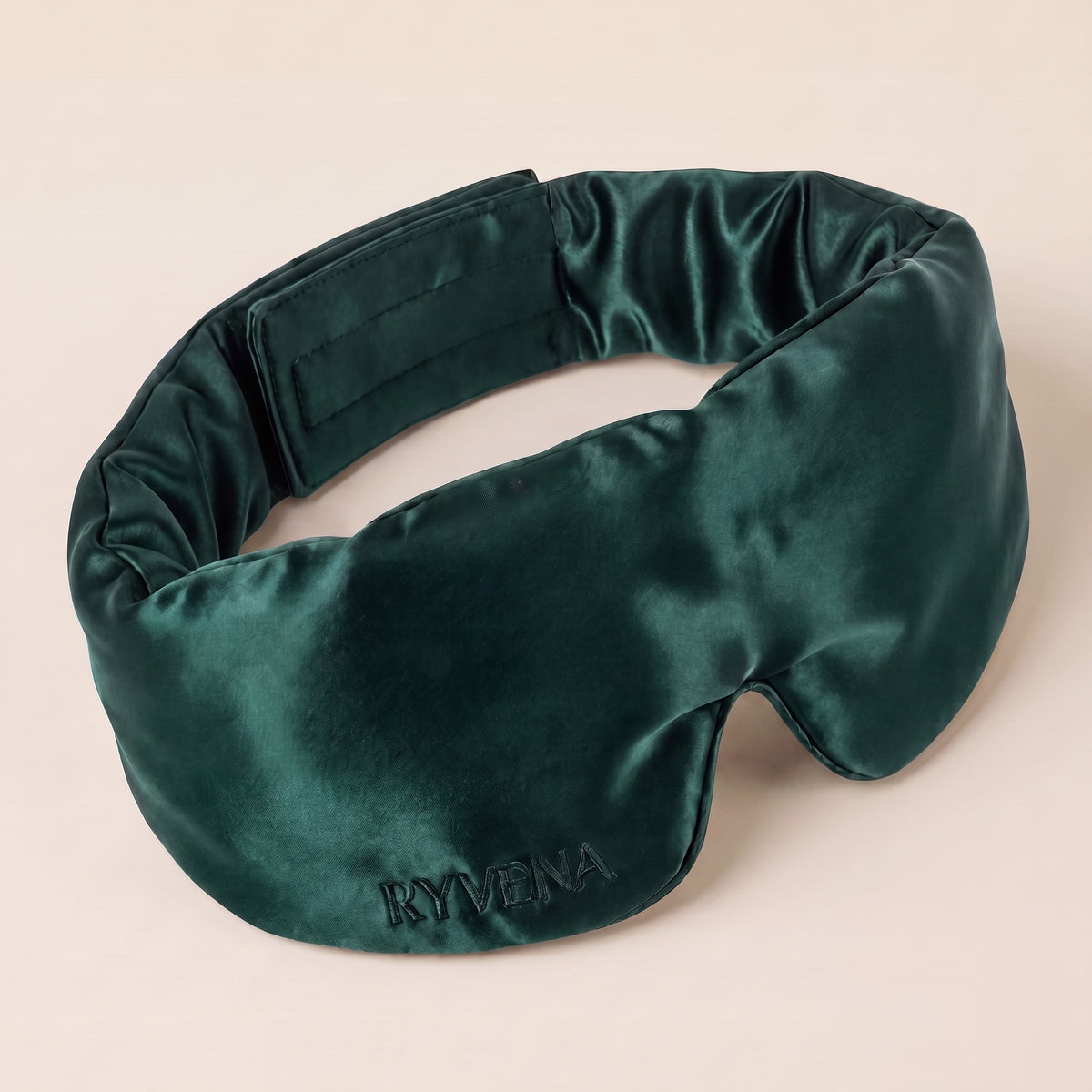 RYVENA contoured silk sleep mask in emerald green, angled to show the 22 momme mulberry silk face and tonal embroidery #colour_emerald green