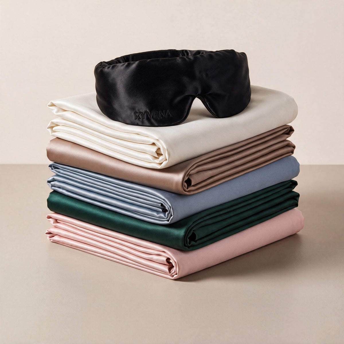 RYVENA Silk Ritual with deep black silk sleep mask on a stack of silk pillowcases#Mask Colour_Deep Black