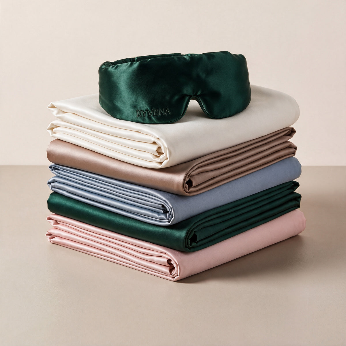 RYVENA Silk Ritual with emerald green silk sleep mask on a stack of silk pillowcases#Mask Colour_Emerald Green