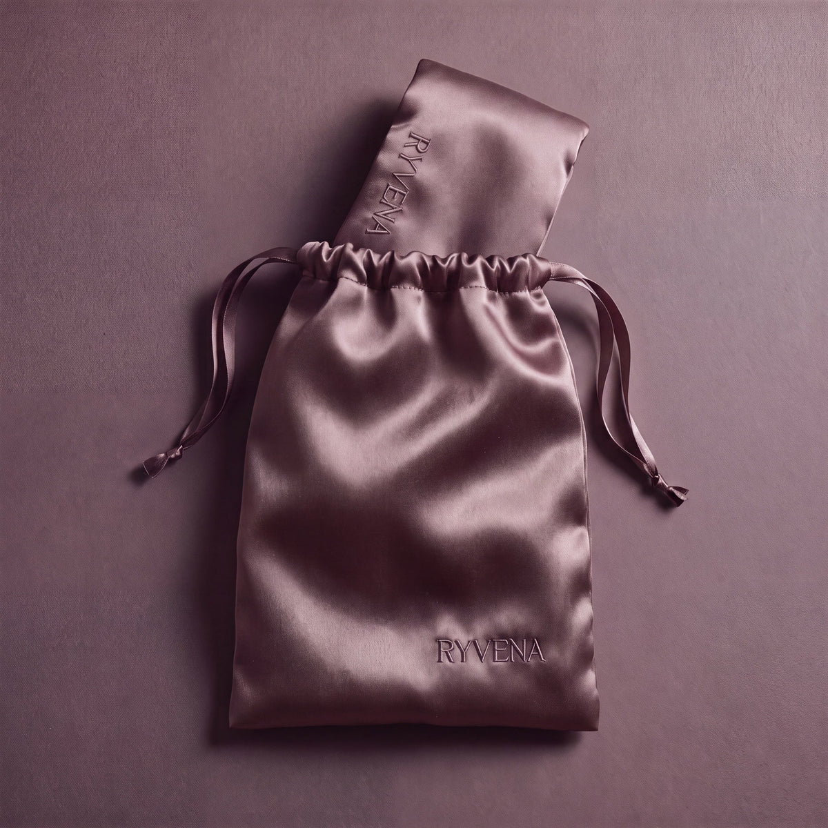 RYVENA blush pink silk sleep mask packed inside its branded silk carry bag