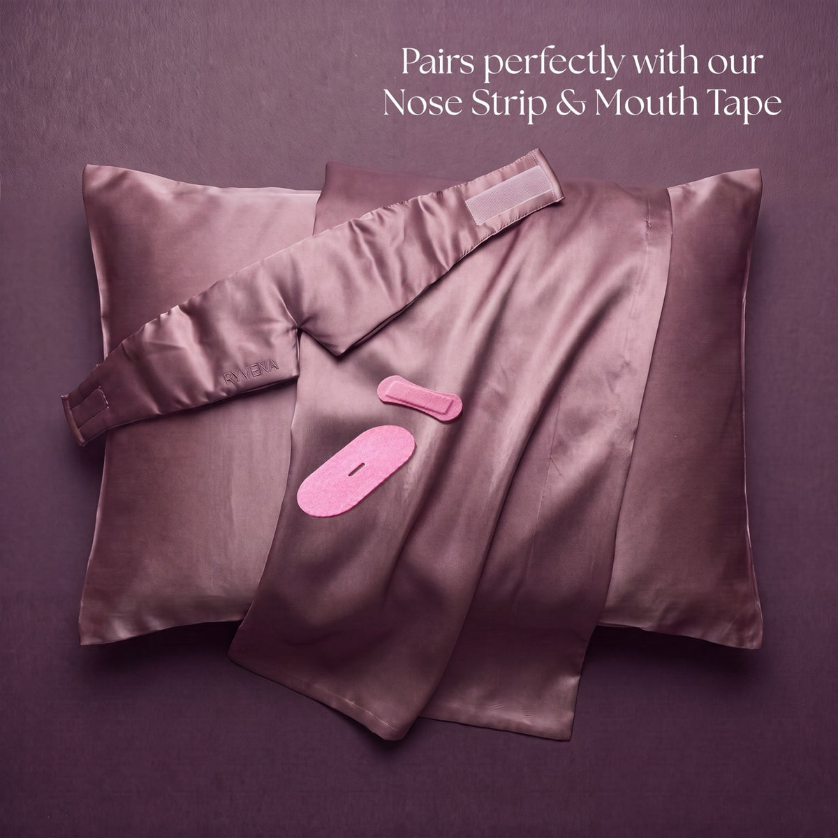 Blush silk pillowcases arranged with a pink RYVENA nose strip, mouth tape and mask