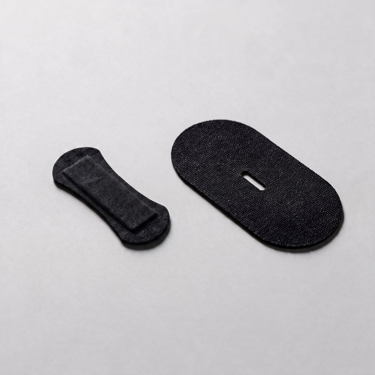 Black RYVENA nose strip beside a black mouth tape, vent slot and spring band visible